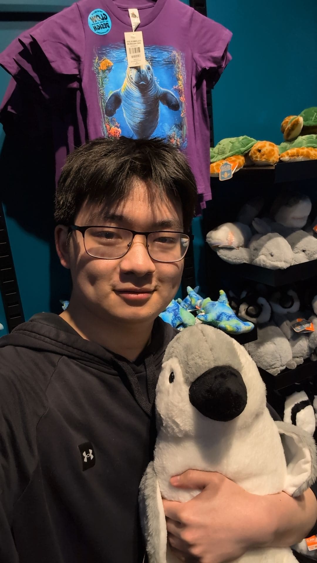 Darren holding a large stuffed toy in a store